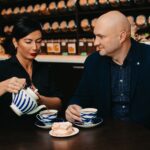 Kahe inimese teetseremoonia kohvikus - teekann ja koogitükk laual